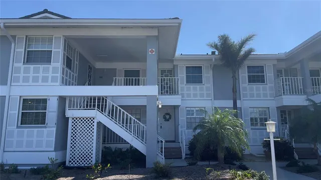 a view of a house with a small yard and wooden floor and fence