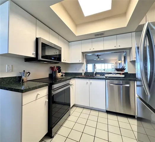 a kitchen with stainless steel appliances granite countertop a stove a sink and a microwave