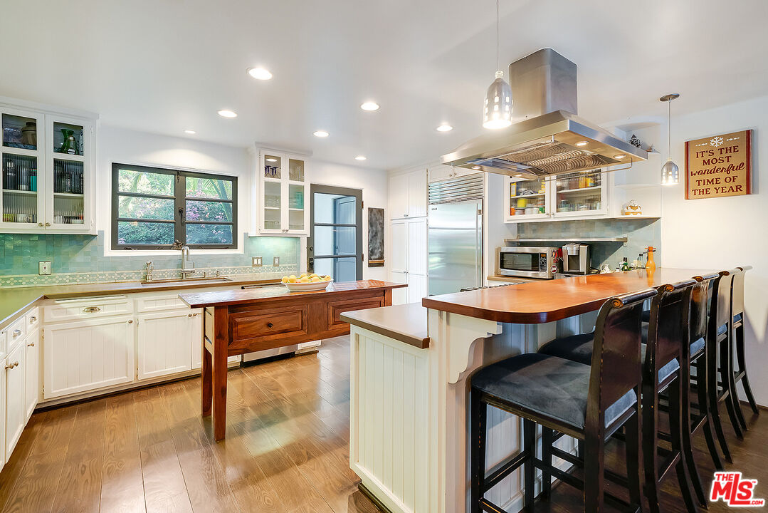 11670 Duque Drive Studio City, CA 91604 - Photo 12 of 48 a kitchen with stainless steel appliances granite countertop a stove a sink dishwasher a dining table and chairs with wooden floor
