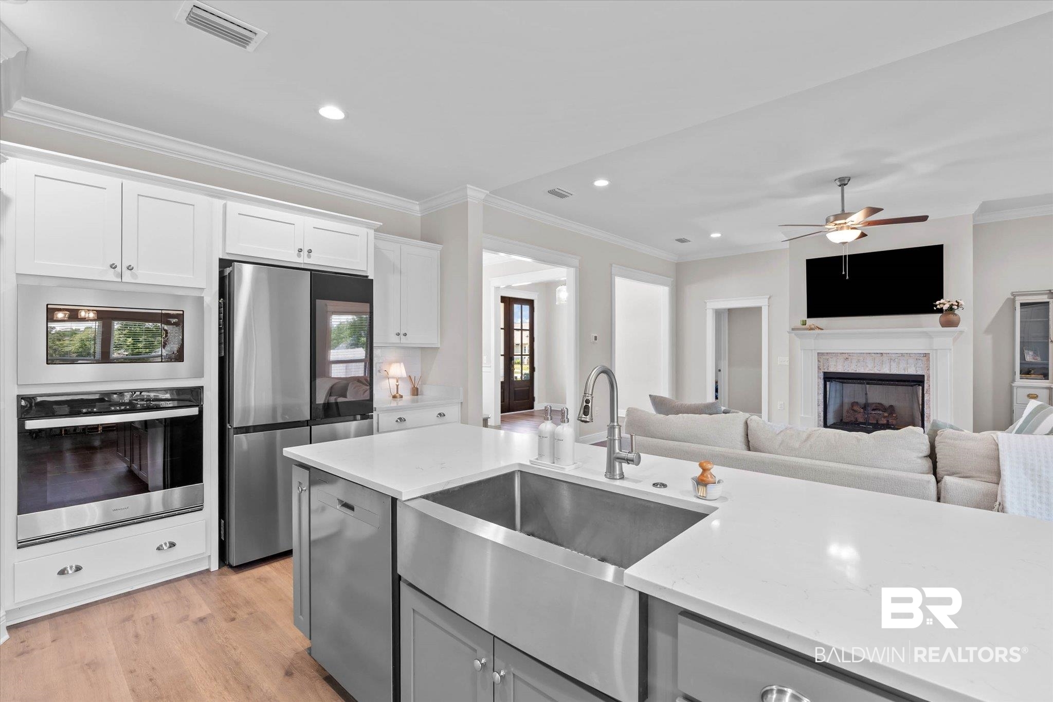 23523 Travis Stock Street Foley, AL 36535 - Photo 10 of 45 Kitchen featuring a large central island with a stainless steel farmhouse sink and gooseneck faucet