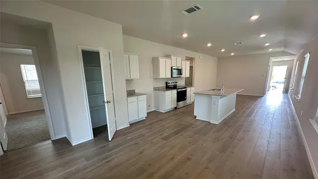 a view of a kitchen with wooden floor and electronic appliances