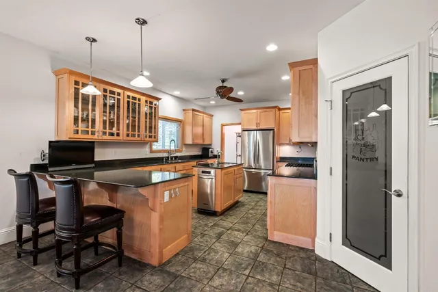 a kitchen with granite countertop a sink stainless steel appliances and cabinets