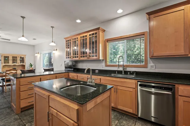 a kitchen with granite countertop a sink stainless steel appliances and cabinets