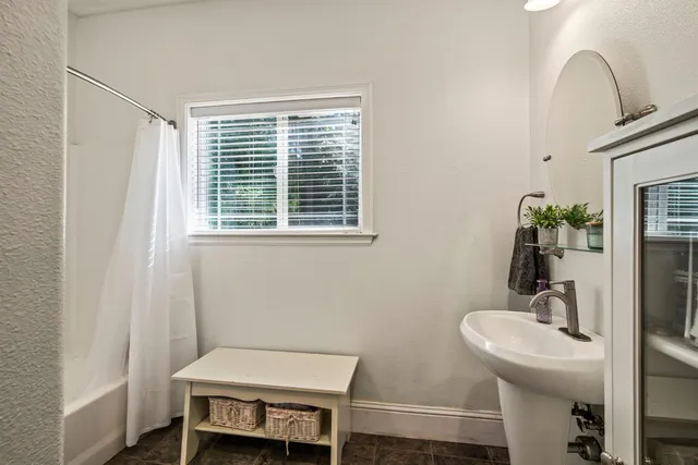 a bedroom with a bed chandelier and a window