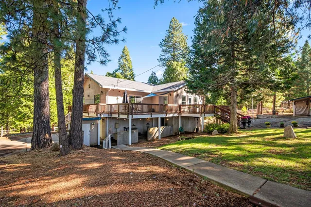a view of a house with a yard and large tree