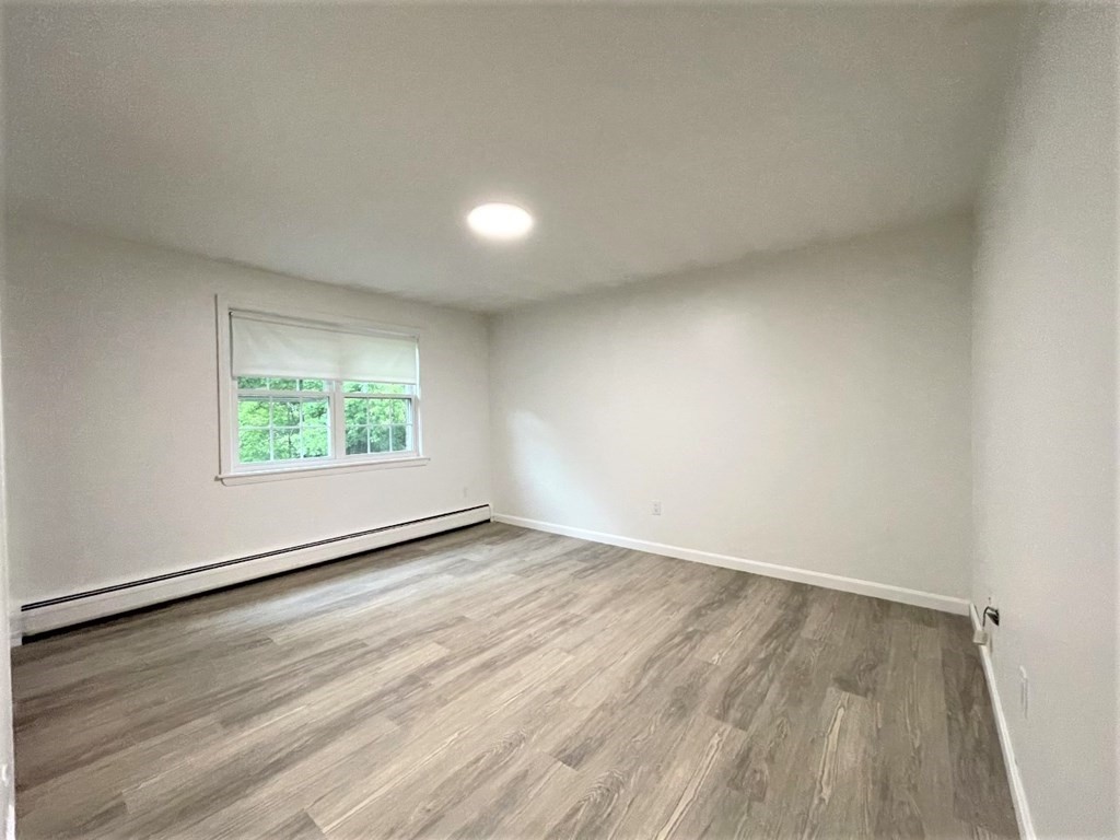 4 Dodge Road, Unit 1A10 Rowley, MA 01969 - Photo 4 of 5 an empty room with wooden floor and windows