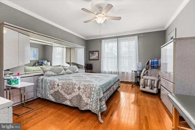 a bedroom with a bed and a dresser with wooden floor