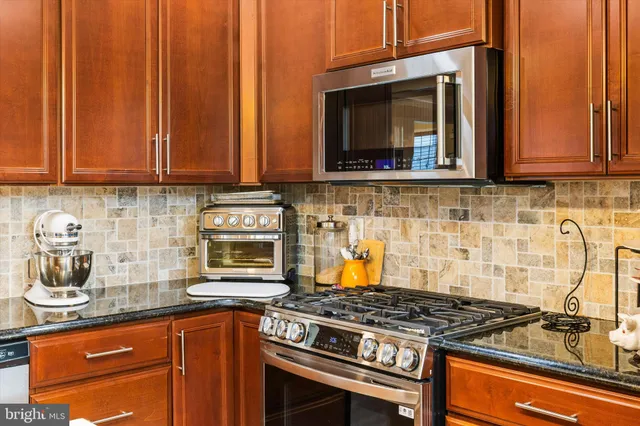a kitchen with stainless steel appliances granite countertop a stove and a microwave