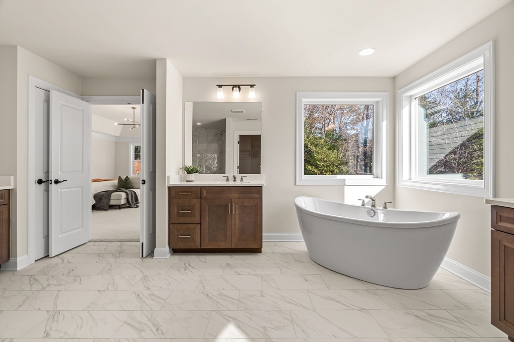 24 Rookery Lane, Unit 6 Concord, MA 01742 - Photo 27 of 41 a spacious bathroom with a tub sink and mirror