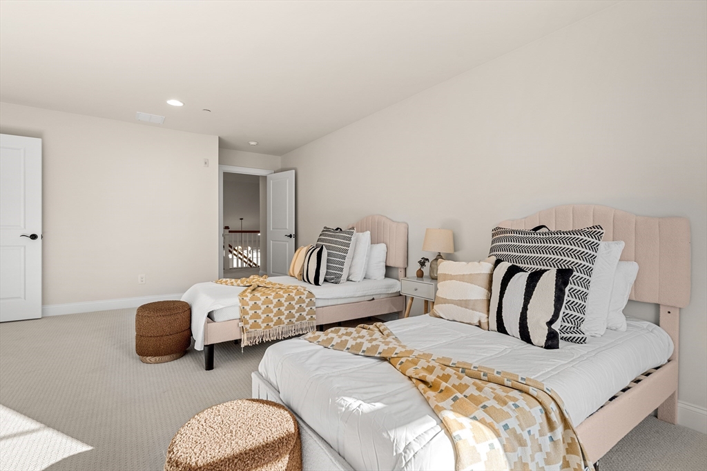 24 Rookery Lane, Unit 6 Concord, MA 01742 - Photo 32 of 41 a bedroom with two beds and a large mirror