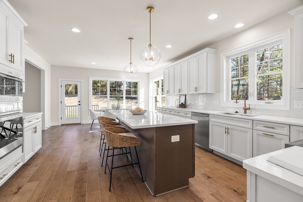 24 Rookery Lane, Unit 6 Concord, MA 01742 - Photo 4 of 41 a kitchen with kitchen island granite countertop a stove a sink a center island and a window