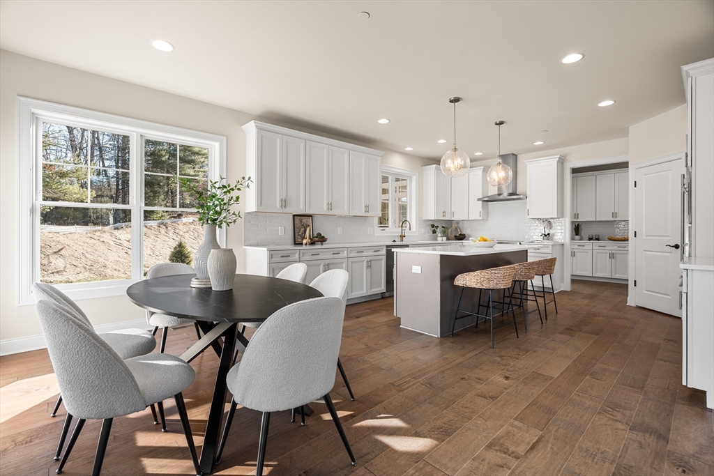 24 Rookery Lane, Unit 6 Concord, MA 01742 - Photo 5 of 41 a kitchen with kitchen island a dining table and chairs