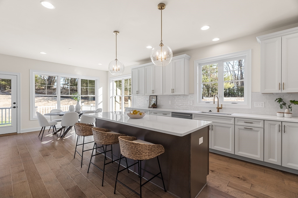 24 Rookery Lane, Unit 6 Concord, MA 01742 - Photo 6 of 41 a kitchen with a stove a sink a dining table and chairs