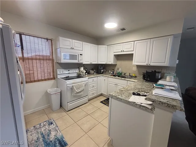 a kitchen with stainless steel appliances a sink a stove a refrigerator and cabinets