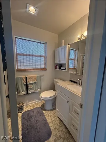 a bathroom with a toilet sink vanity and mirror