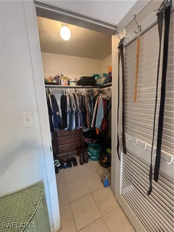 a view of walk in closet with clothes and shoes