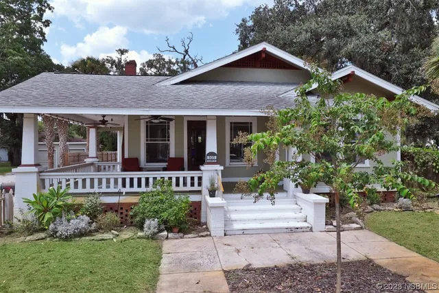 a front view of a house with a yard table and chairs