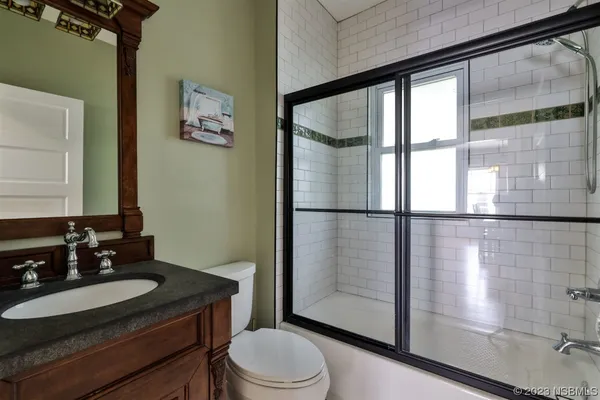 a view of house with a large tree and wooden fence
