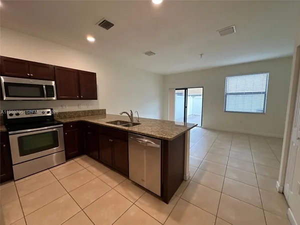 a kitchen with stainless steel appliances granite countertop a stove and a sink