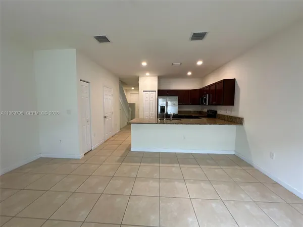 a view of kitchen with refrigerator and window