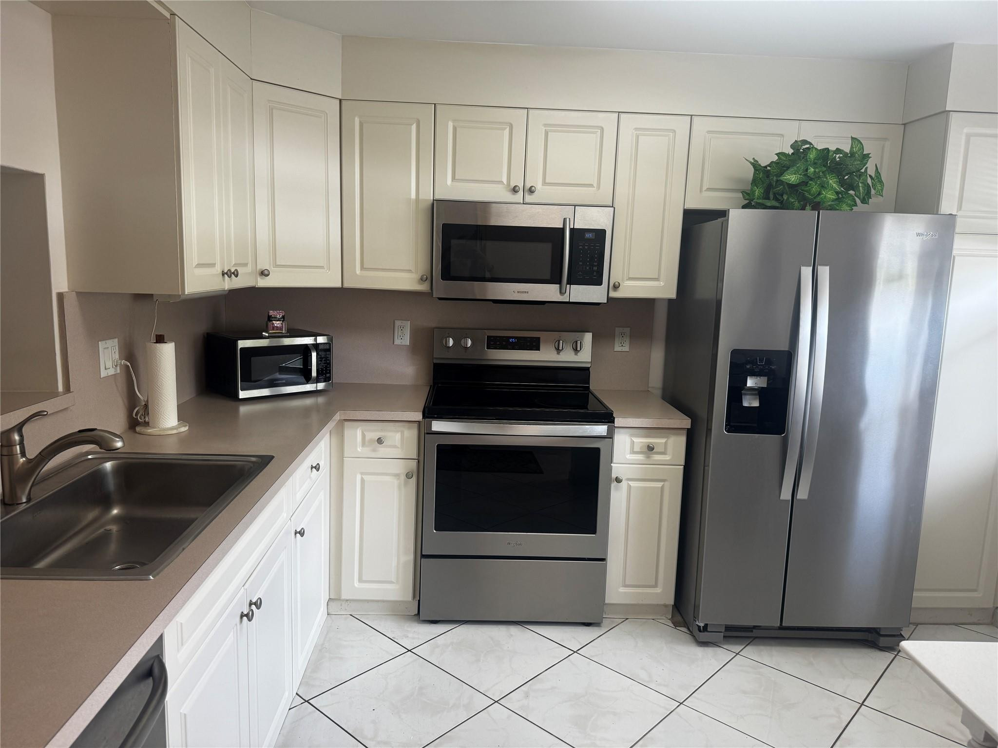 3302 Aruba Way, Unit M1 Coconut Creek, FL 33066 - Photo 1 of 58 a kitchen with stainless steel appliances granite countertop a refrigerator stove and sink