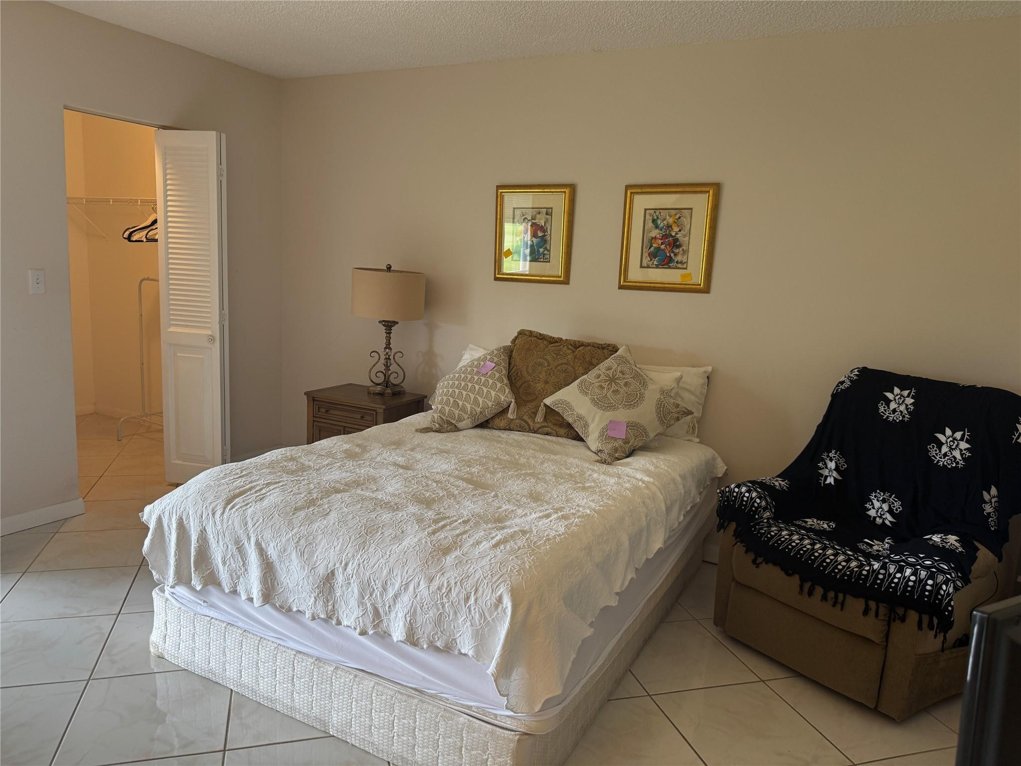 3302 Aruba Way, Unit M1 Coconut Creek, FL 33066 - Photo 16 of 58 a bedroom with a bed and wall painting