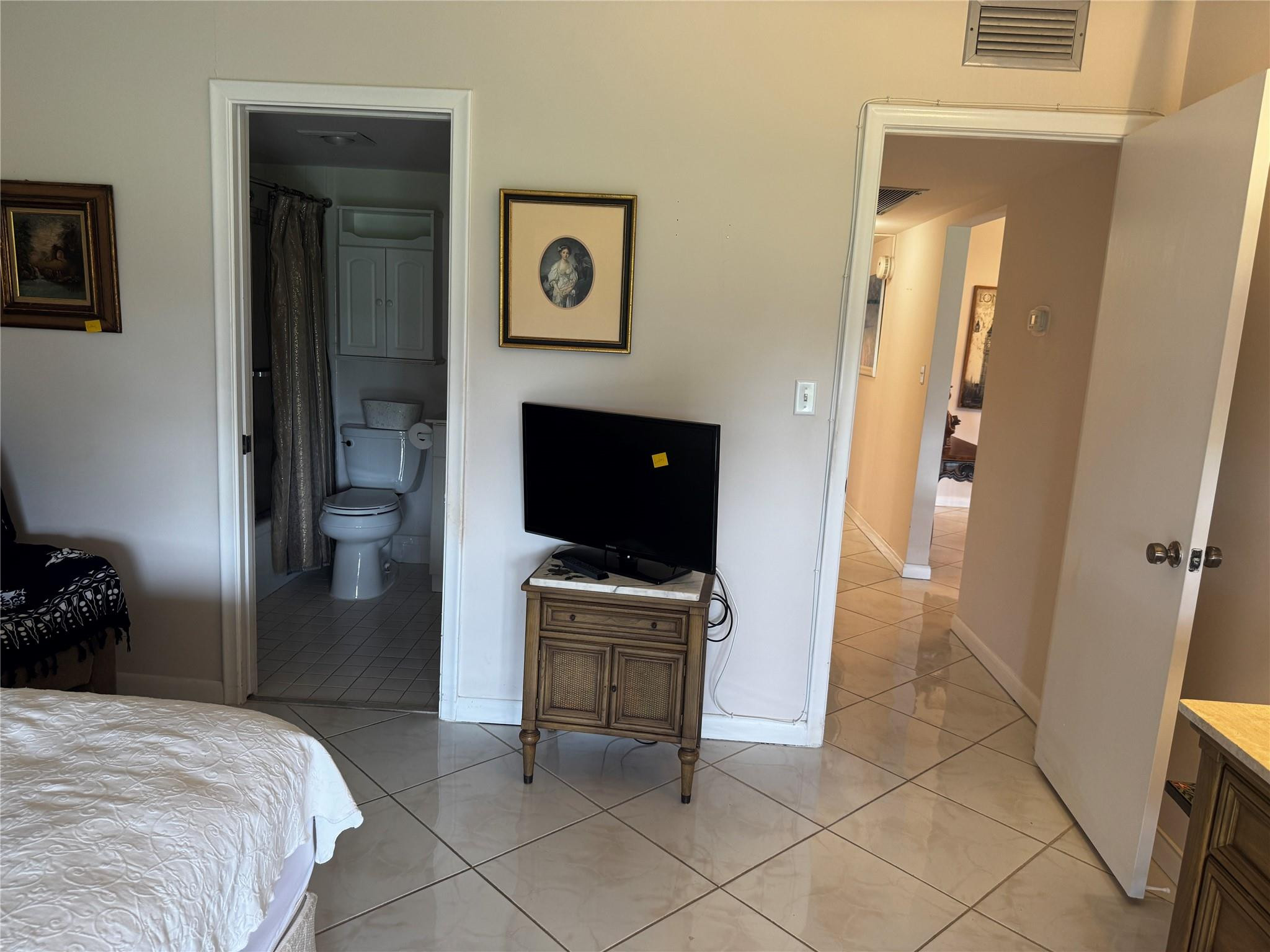 3302 Aruba Way, Unit M1 Coconut Creek, FL 33066 - Photo 18 of 58 a bedroom with a bed and a television in it