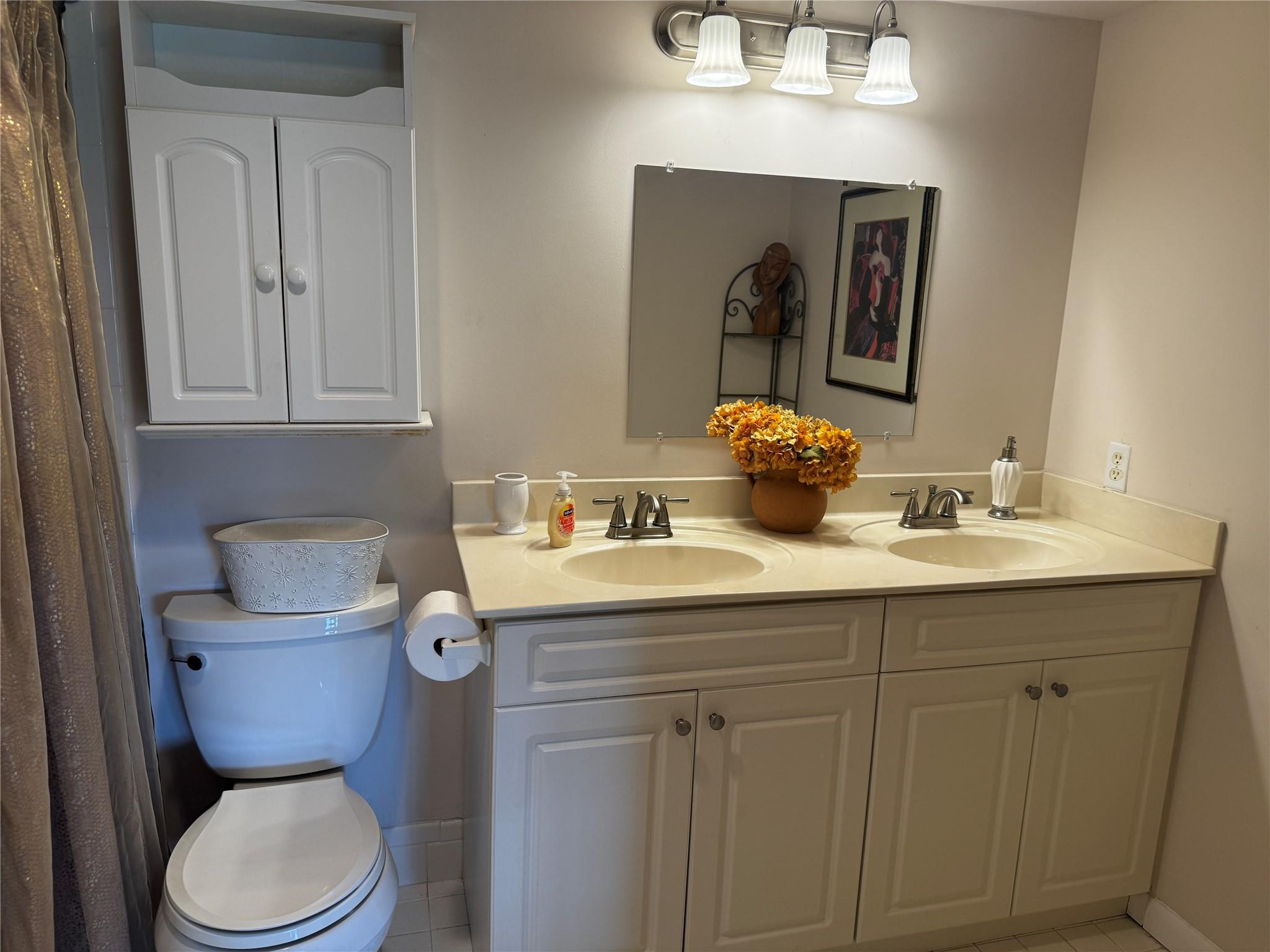 3302 Aruba Way, Unit M1 Coconut Creek, FL 33066 - Photo 19 of 58 a bathroom with a toilet a sink and mirror