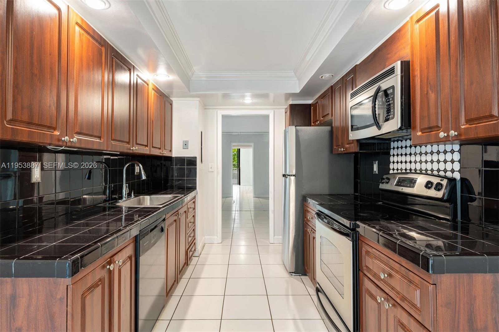 2000 Towerside Terrace, Unit 608 Miami, FL 33138 - Photo 15 of 44 a kitchen with stainless steel appliances granite countertop a stove sink and cabinets