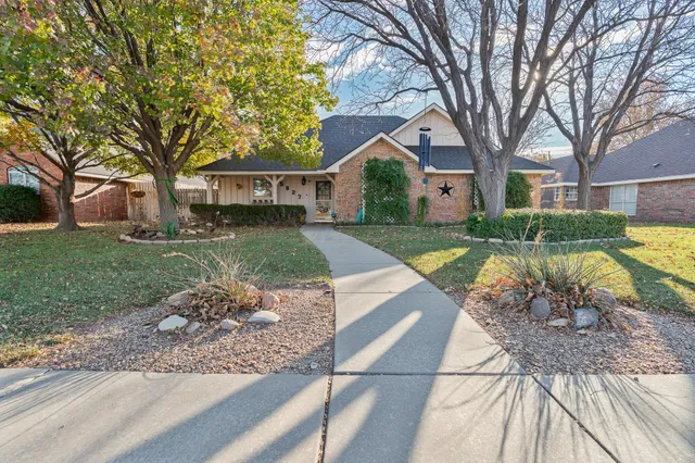 a view of a yard with a house and a tree with plants