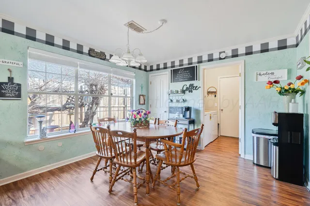 a dining room with furniture a chandelier and wooden floor