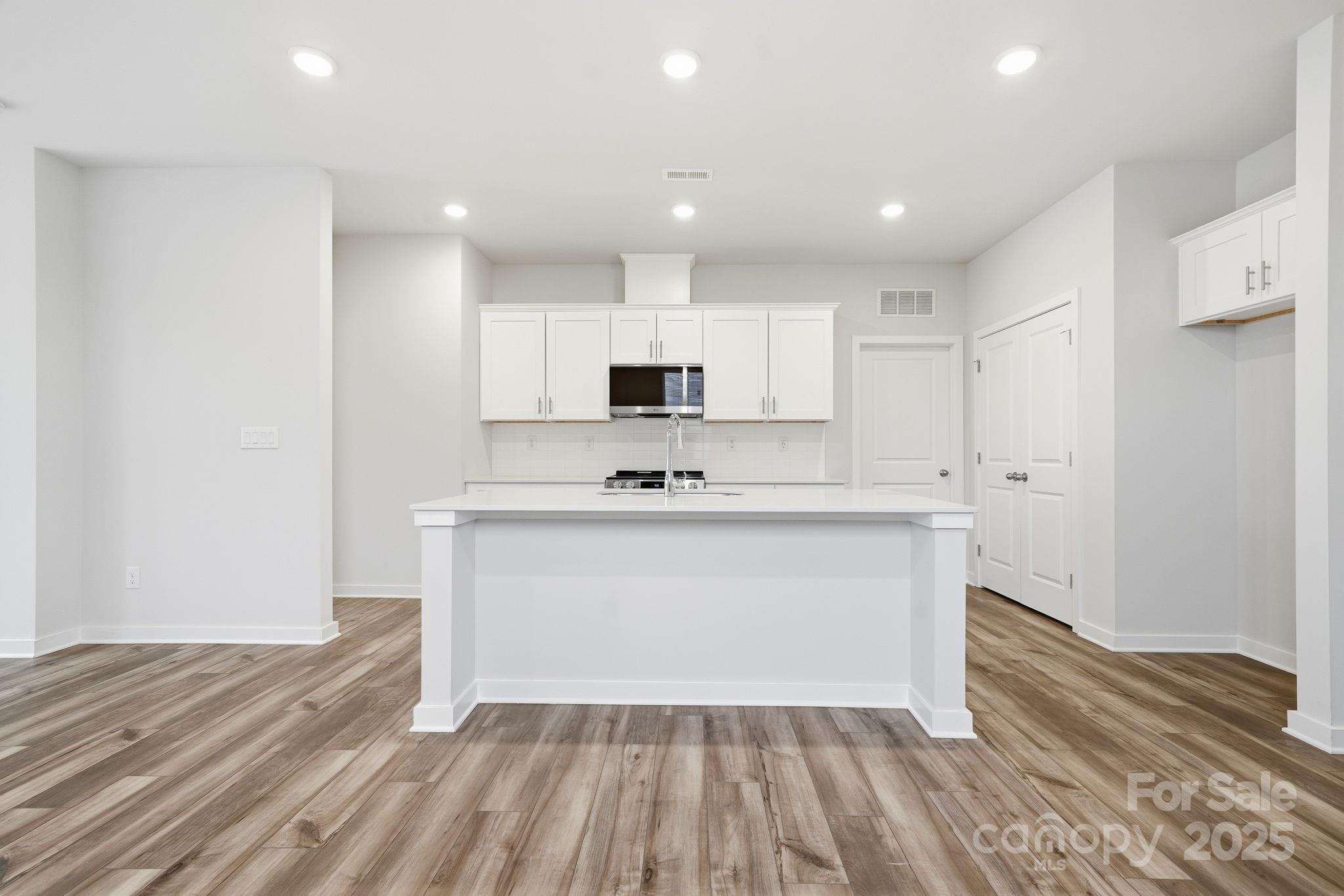 8038 Midas Lane Locust, NC 28097 - Photo 10 of 11 a view of kitchen appliances cabinets and wooden floor