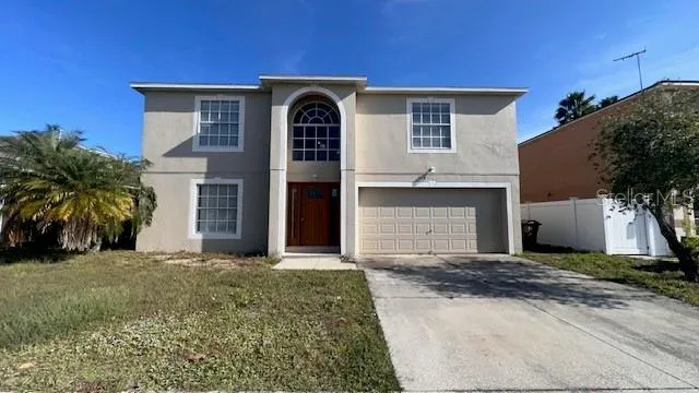 a front view of a house with yard and tress