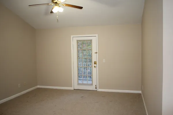 an empty room with a chandelier fan