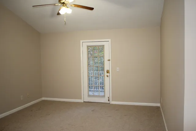 an empty room with a chandelier fan