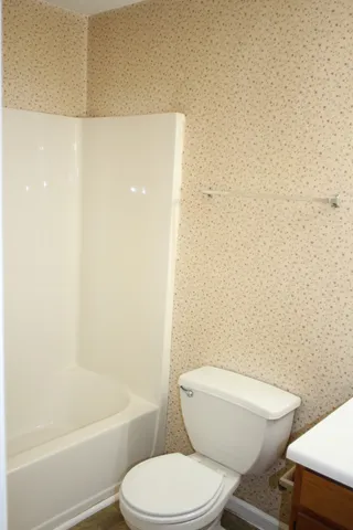 a white toilet and tub next to a shower