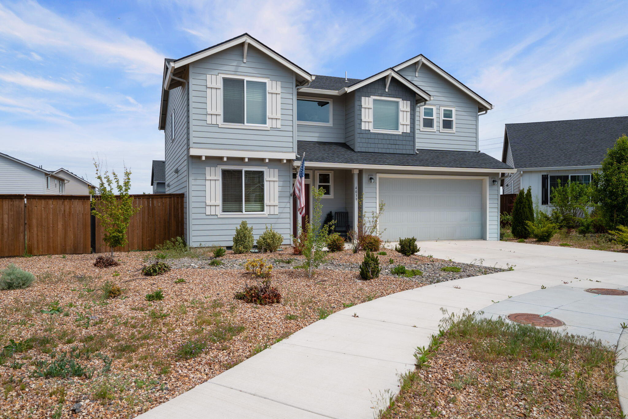 4039 Southwest Quartz Place Redmond, OR 97756 - Photo 4 of 44 a front view of a house with a yard and garage