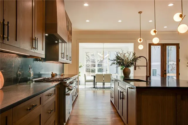 a kitchen with stainless steel appliances granite countertop a stove a sink and a wooden cabinets