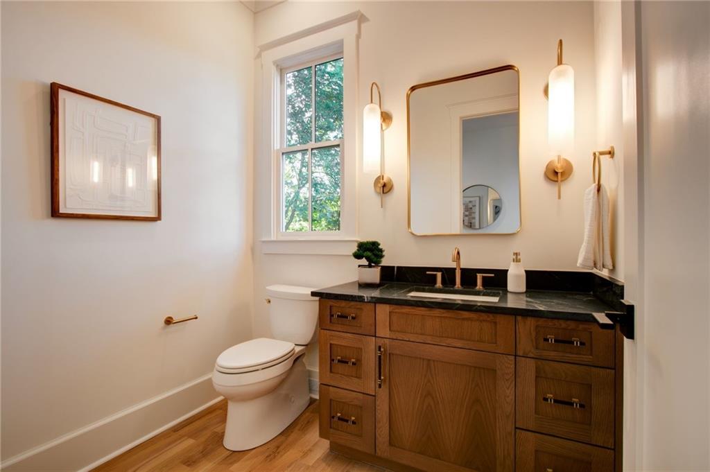 581 Sherwood Road Northeast Atlanta, GA 30324 - Photo 20 of 92 a bathroom with a granite countertop toilet a sink a mirror and a window