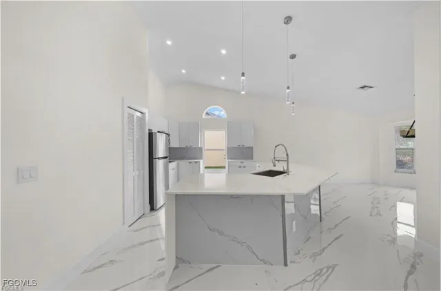 a large white kitchen with cabinets