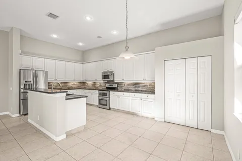 a kitchen with granite countertop a sink stove top oven and cabinets