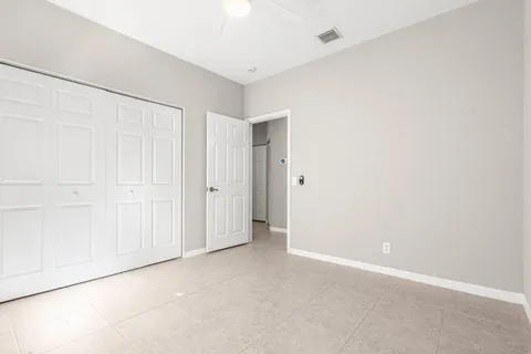 an empty room with windows and fan