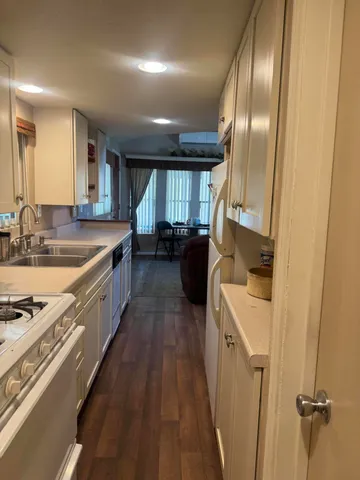 a large kitchen with stainless steel appliances granite countertop a lot of counter space and wooden floors