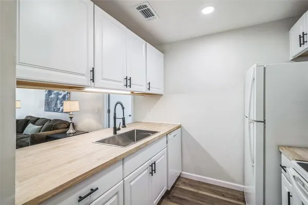 a kitchen with stainless steel appliances granite countertop a sink and a refrigerator