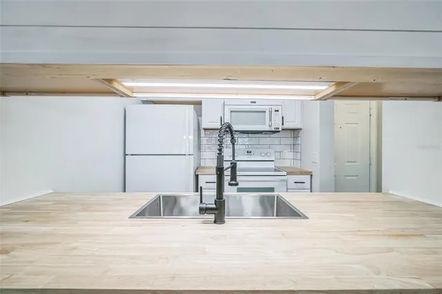 a kitchen with stainless steel appliances kitchen island sink refrigerator and stove