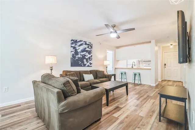 a living room with furniture a lamp and a rug