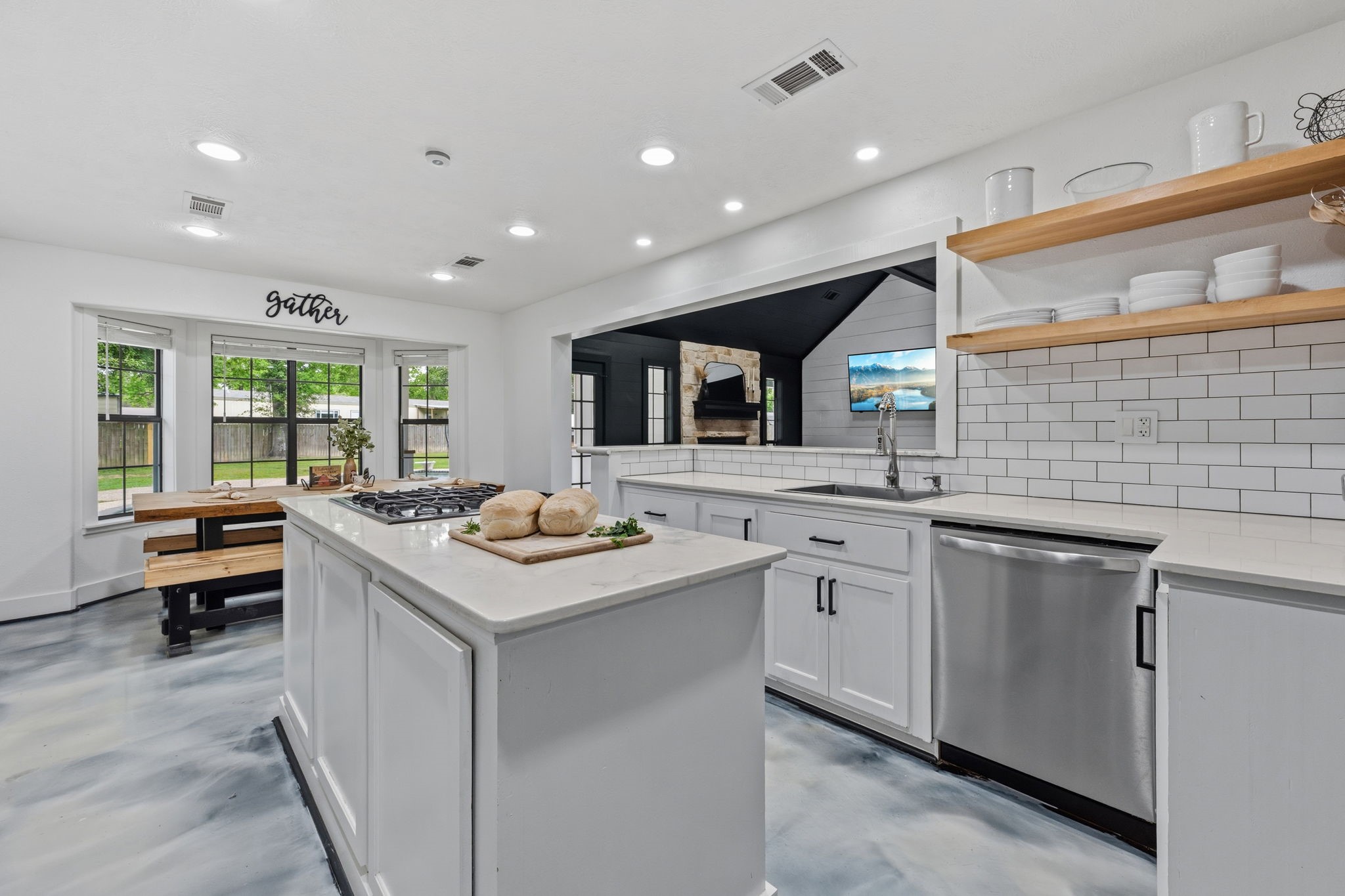 18 East Old Field Road Huffman, TX 77336 - Photo 11 of 35 Another stunning angle of the kitchen highlighting the oversized island, extensive prep space, open shelving, stainless steel appliances, & effortless connection to the dining area and family room.