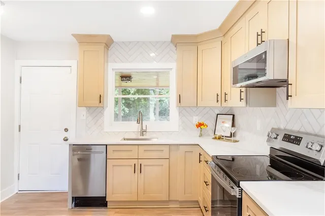 a kitchen with stainless steel appliances granite countertop a sink stove and cabinets