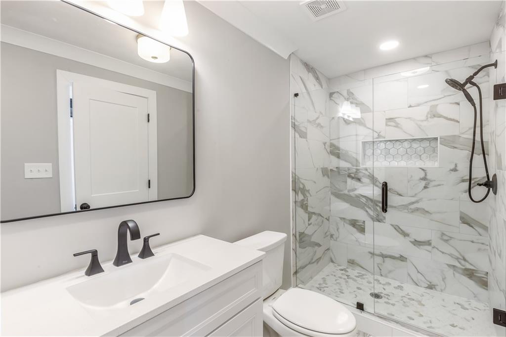 2260 Old Spring Road Smyrna, GA 30080 - Photo 5 of 29 a bathroom with a sink toilet vanity and shower