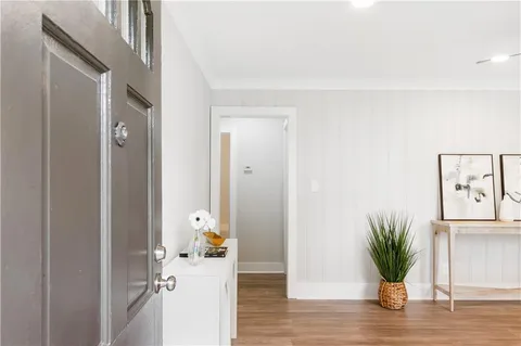 a view of a hallway with wooden floor and a potted plant